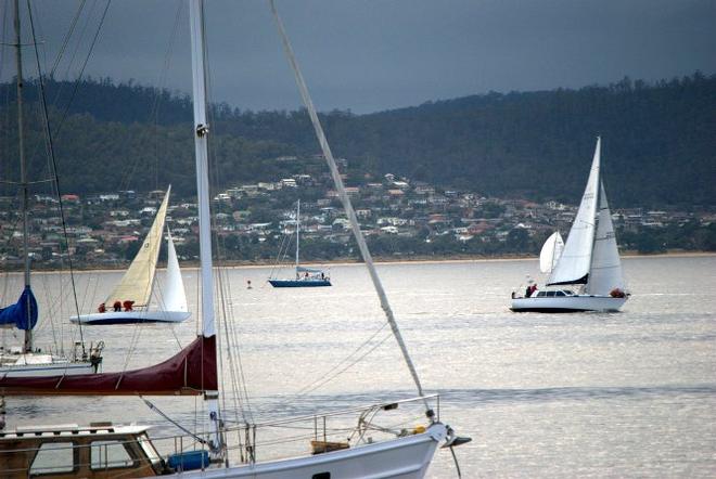 Division three leaders sail past moored yachts in Sandy Bay ©  Peter Campbell